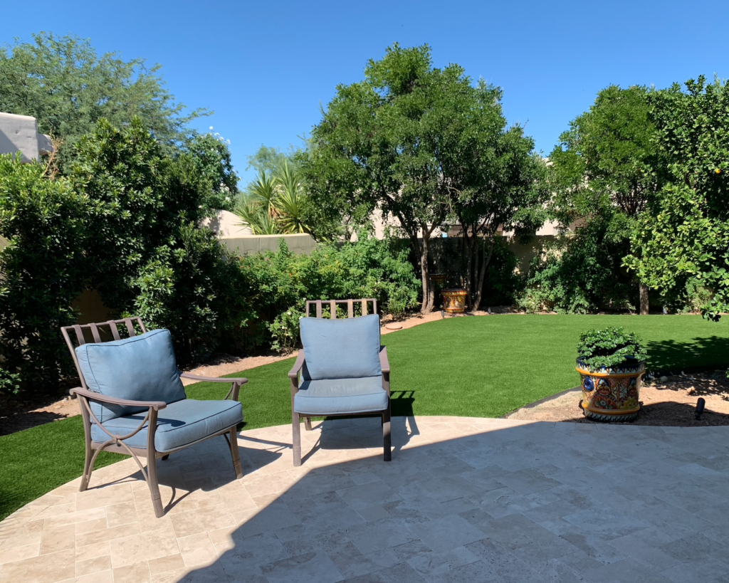 Cave Creek back after outdoor living space renovation with travertine installation and artificial turf